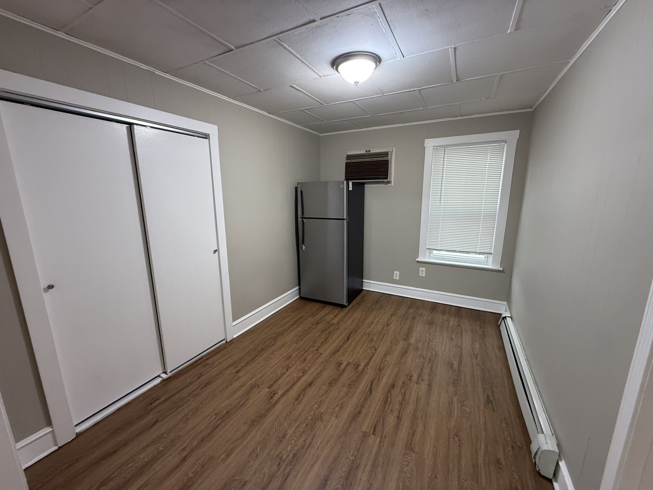 Dining area second angle with storage closet, second refrigerator location, and window air conditioner