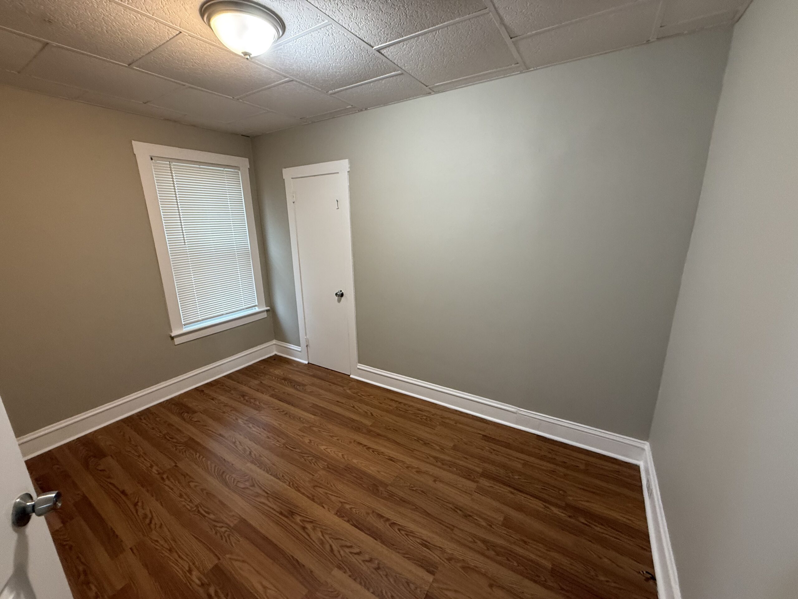 Master bedroom with double-hung windows and hardwood floor