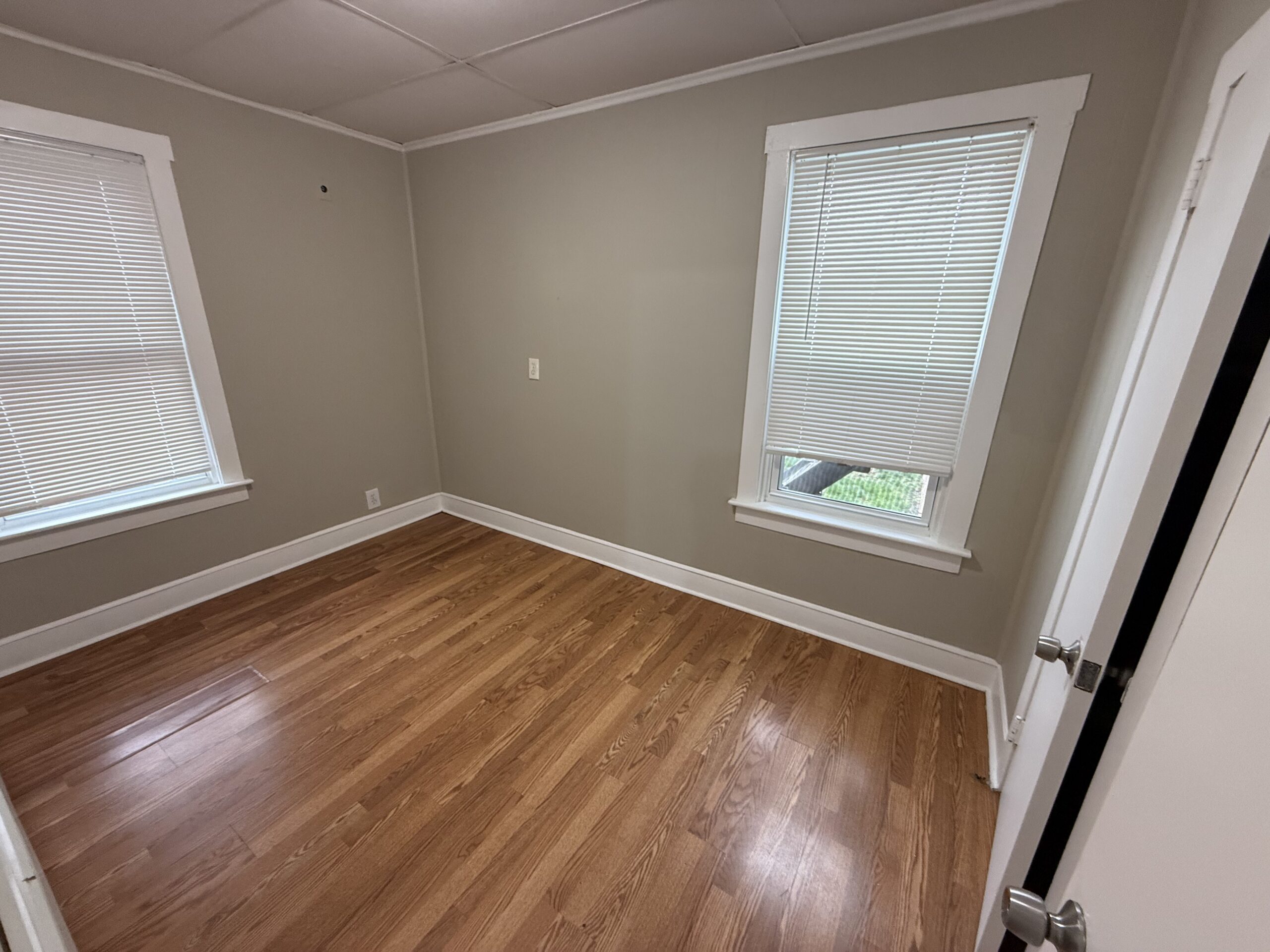 Bedroom 1 with hardwood floors and natural light