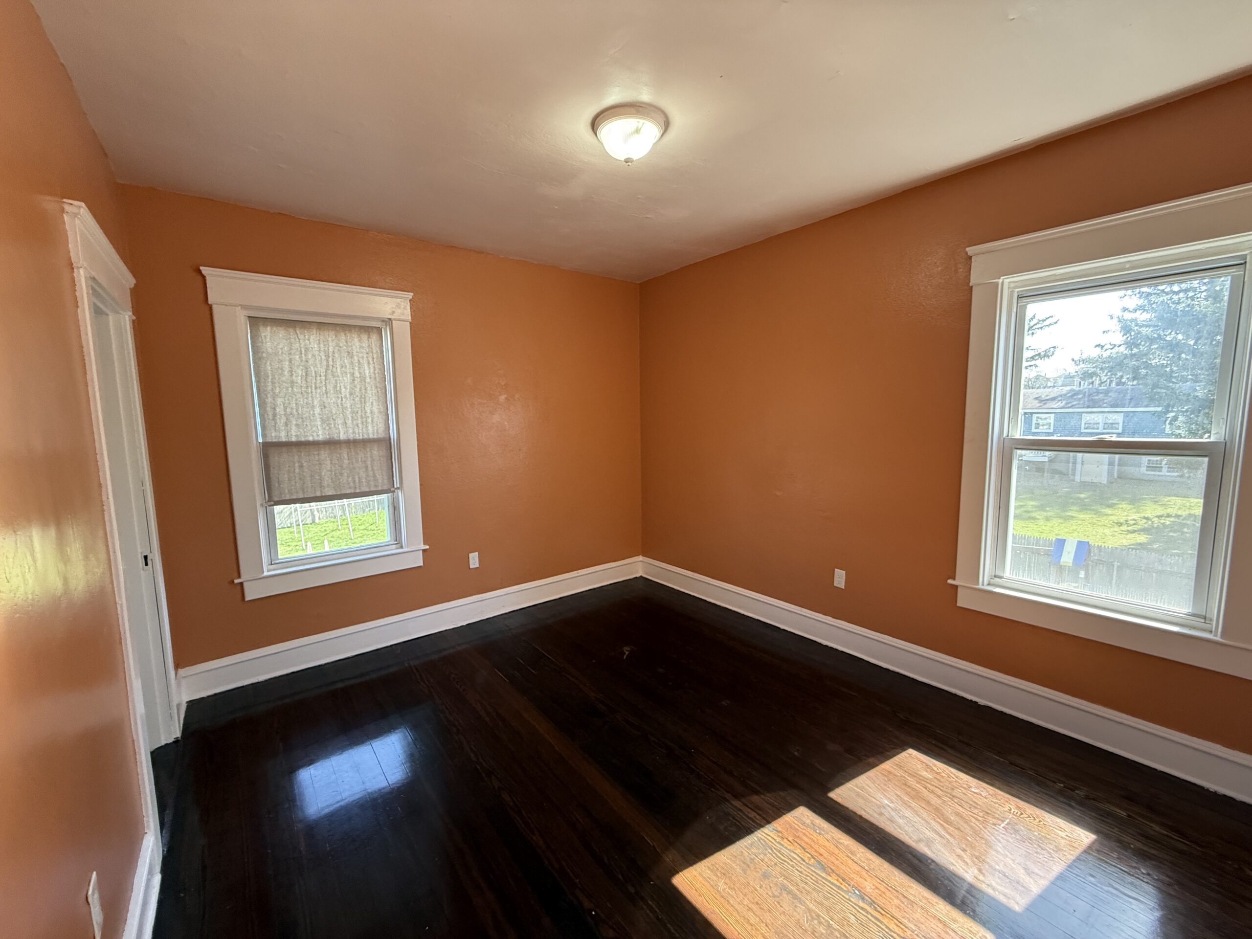Sunny bedroom with hardwood floors and two windows at 170 King Street Unit 2, Fall River MA