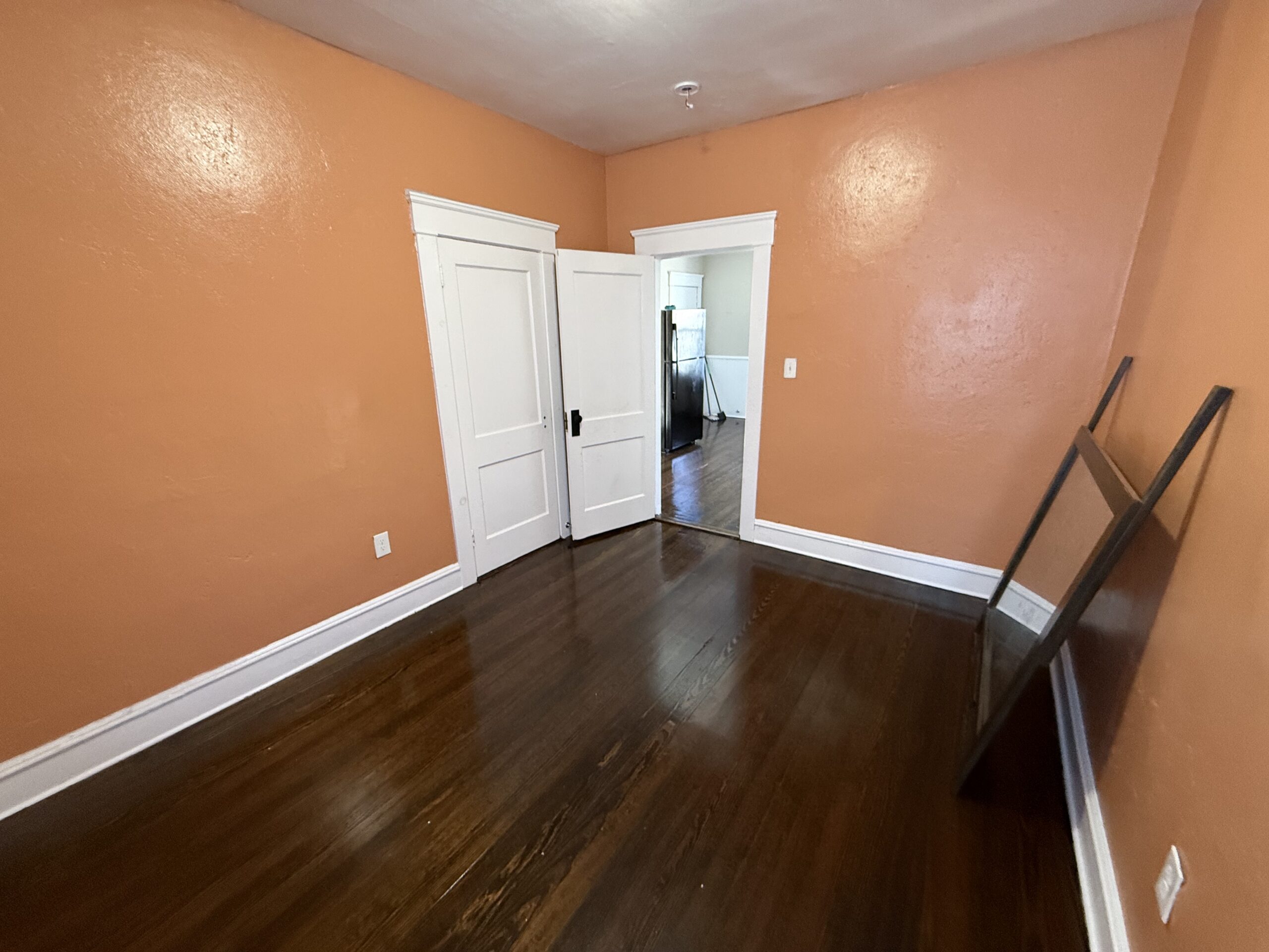 Bedroom with paired wood doors opening to kitchen at 170 King Street, Fall River MA