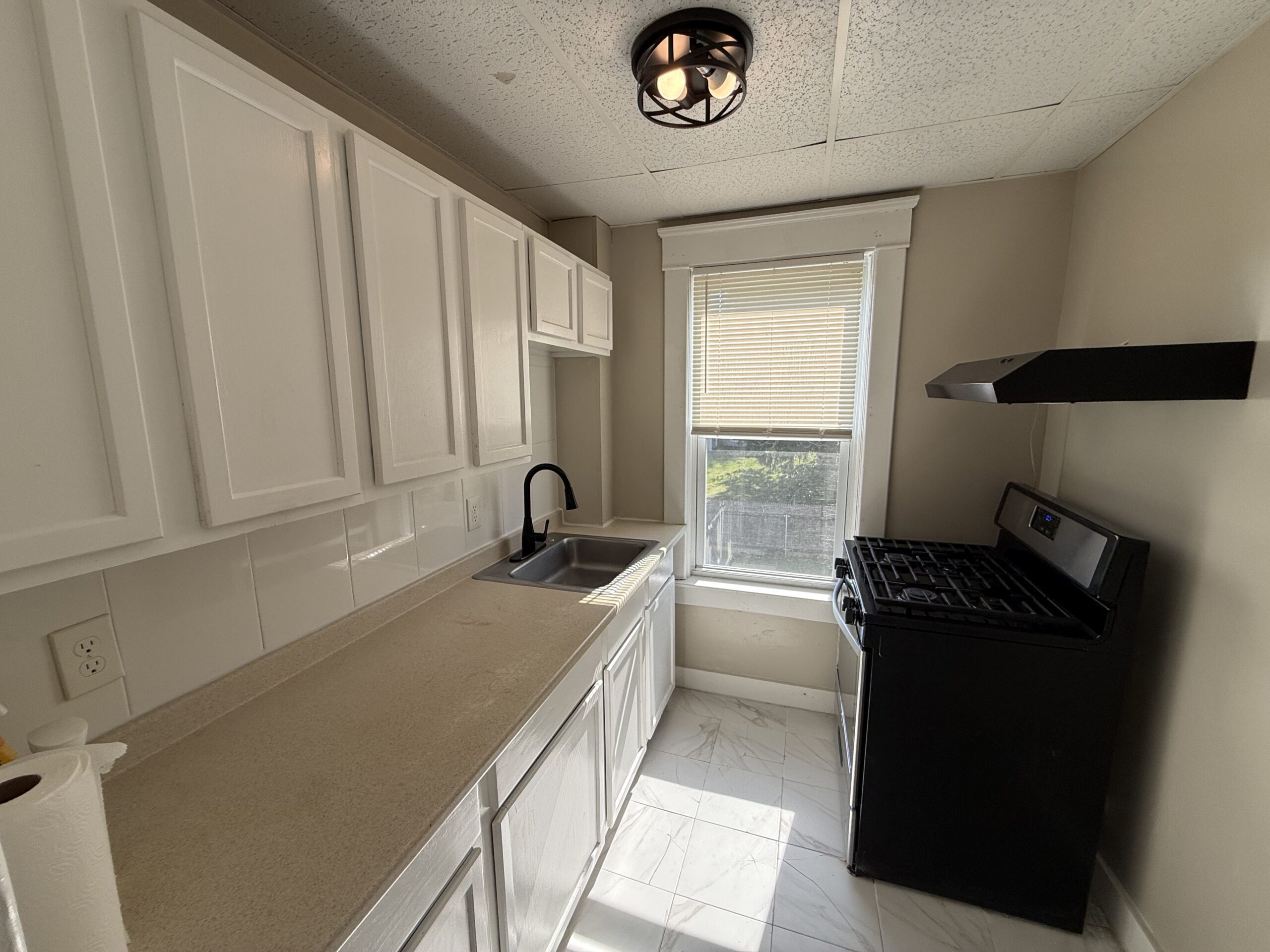 White-cabinet kitchen with gas stove and tile floor at 170 King Street Unit 2, Fall River MA