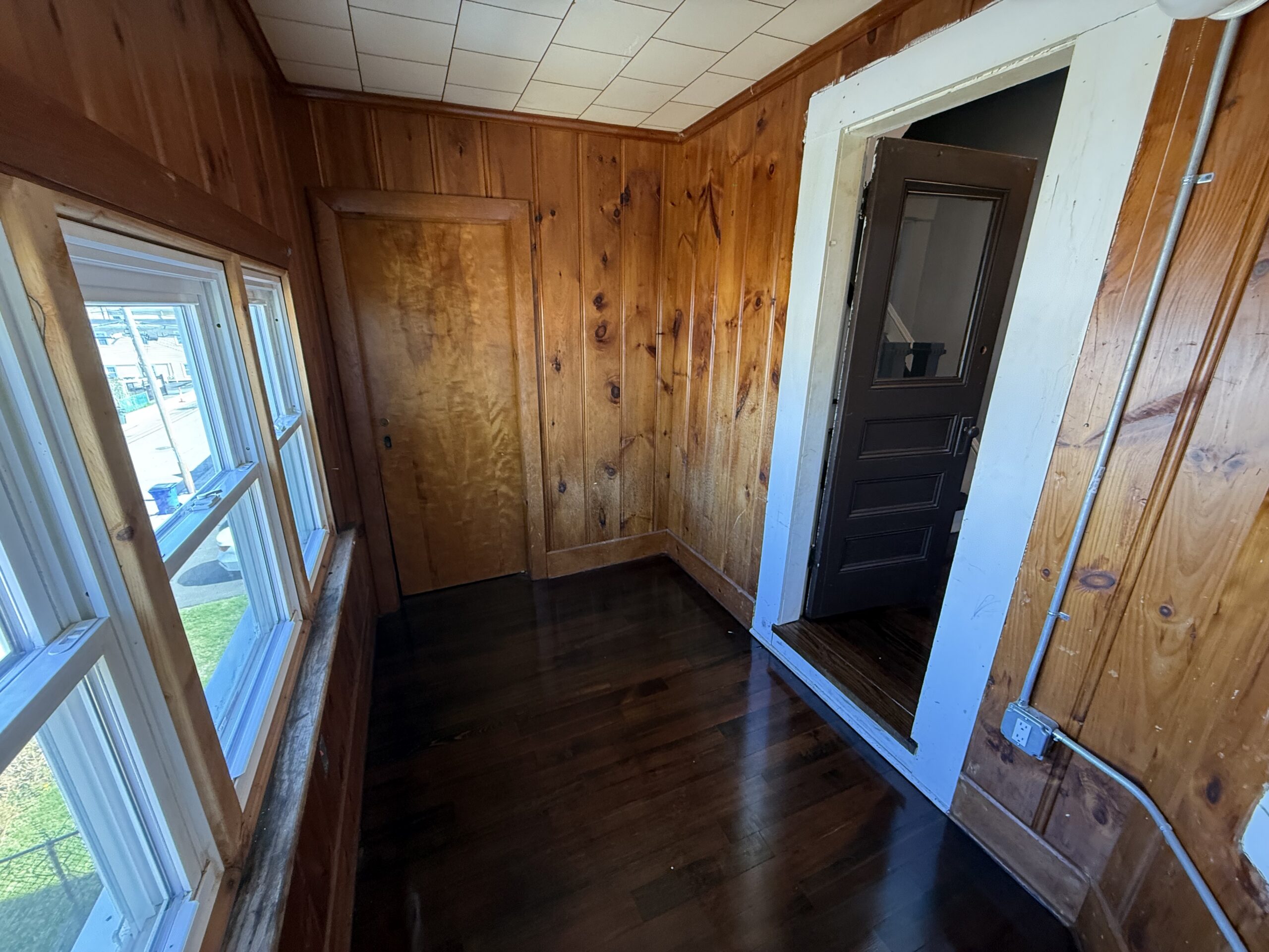 Sun porch with rear door and pine paneling at 170 King Street Unit 2, Fall River MA