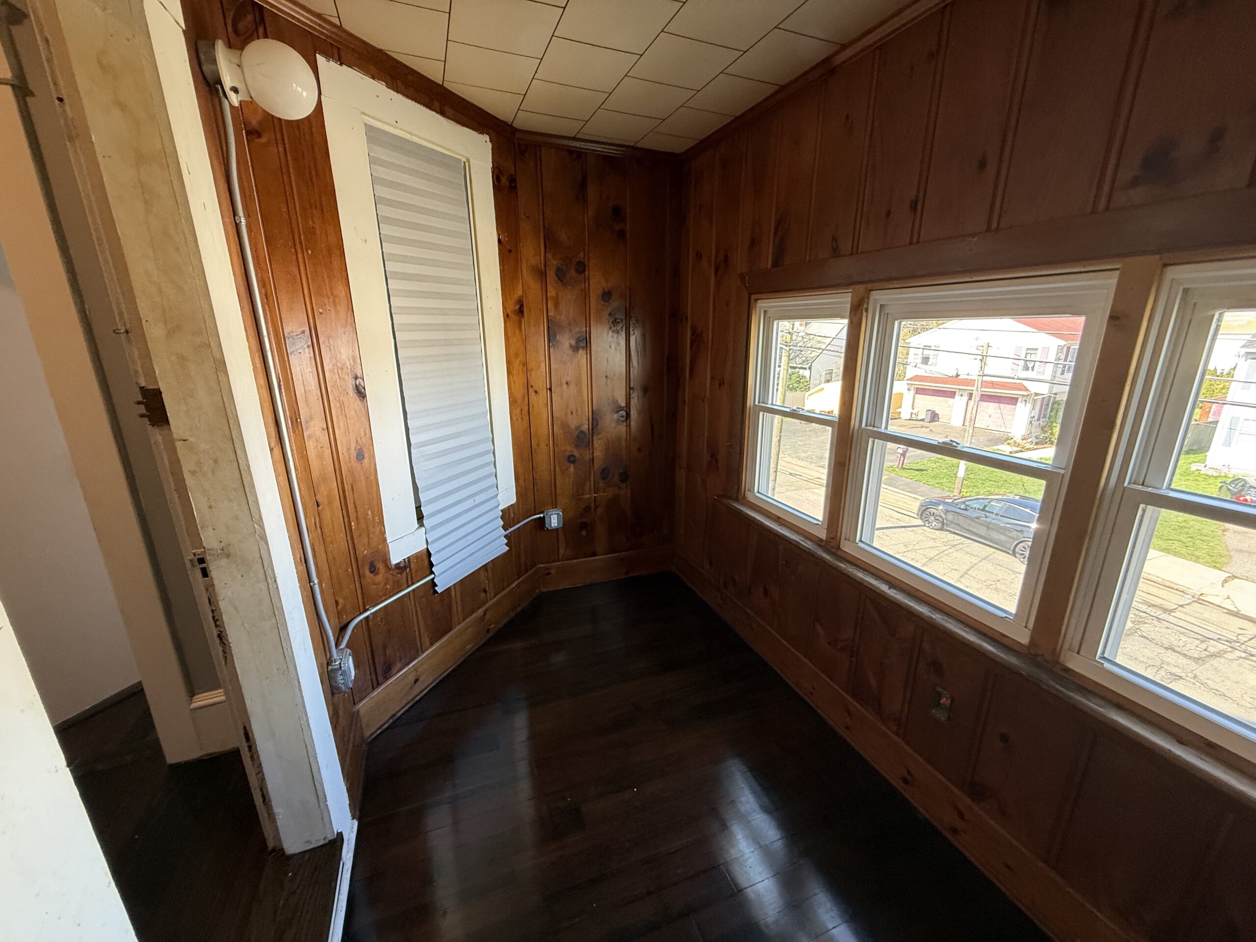 Enclosed sun porch with knotty pine paneling and street view at 170 King Street, Fall River MA