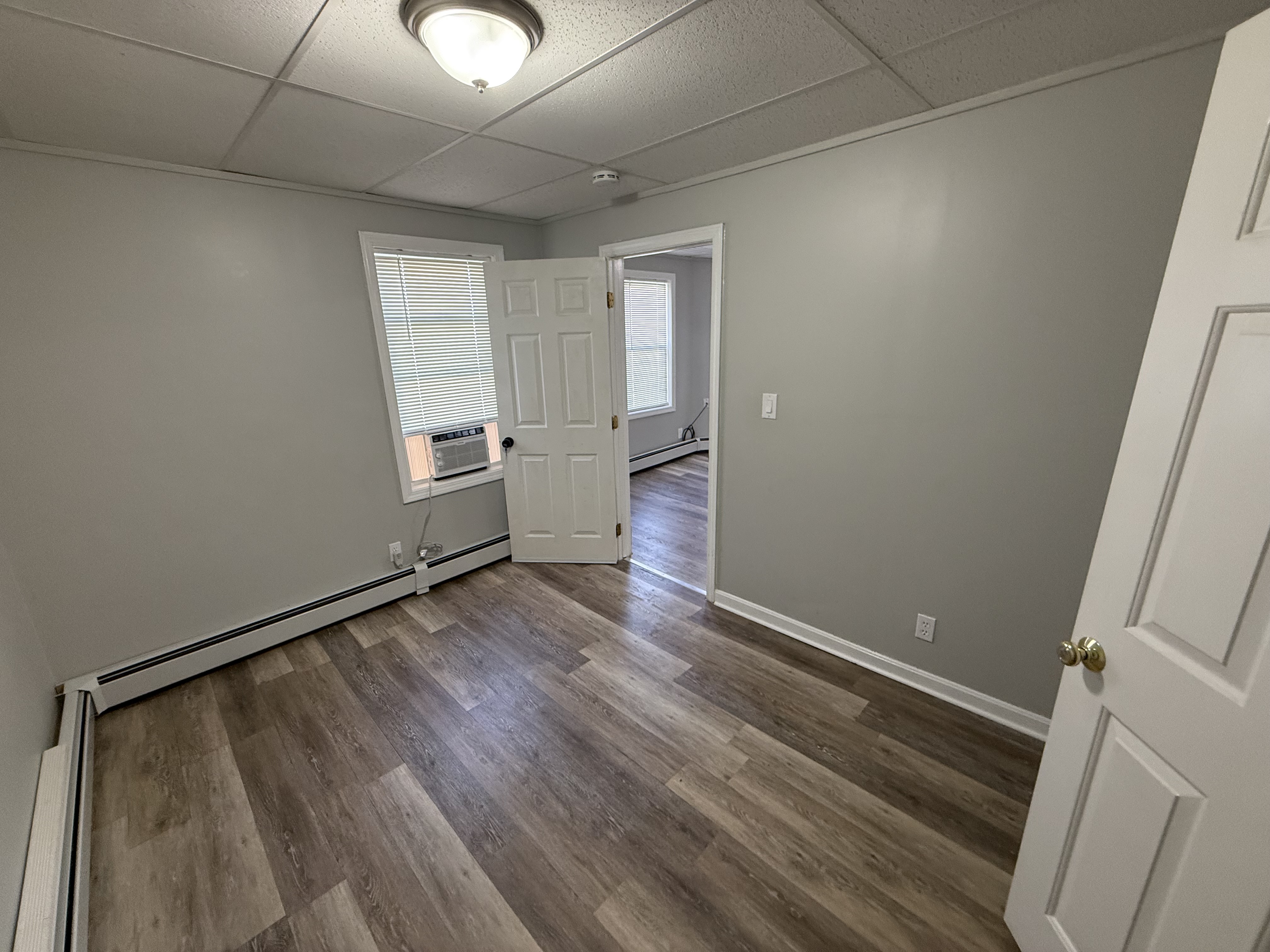 Bedroom 1 alternate angle showing baseboard heat and natural light at 41 Donnelly St Apt 2