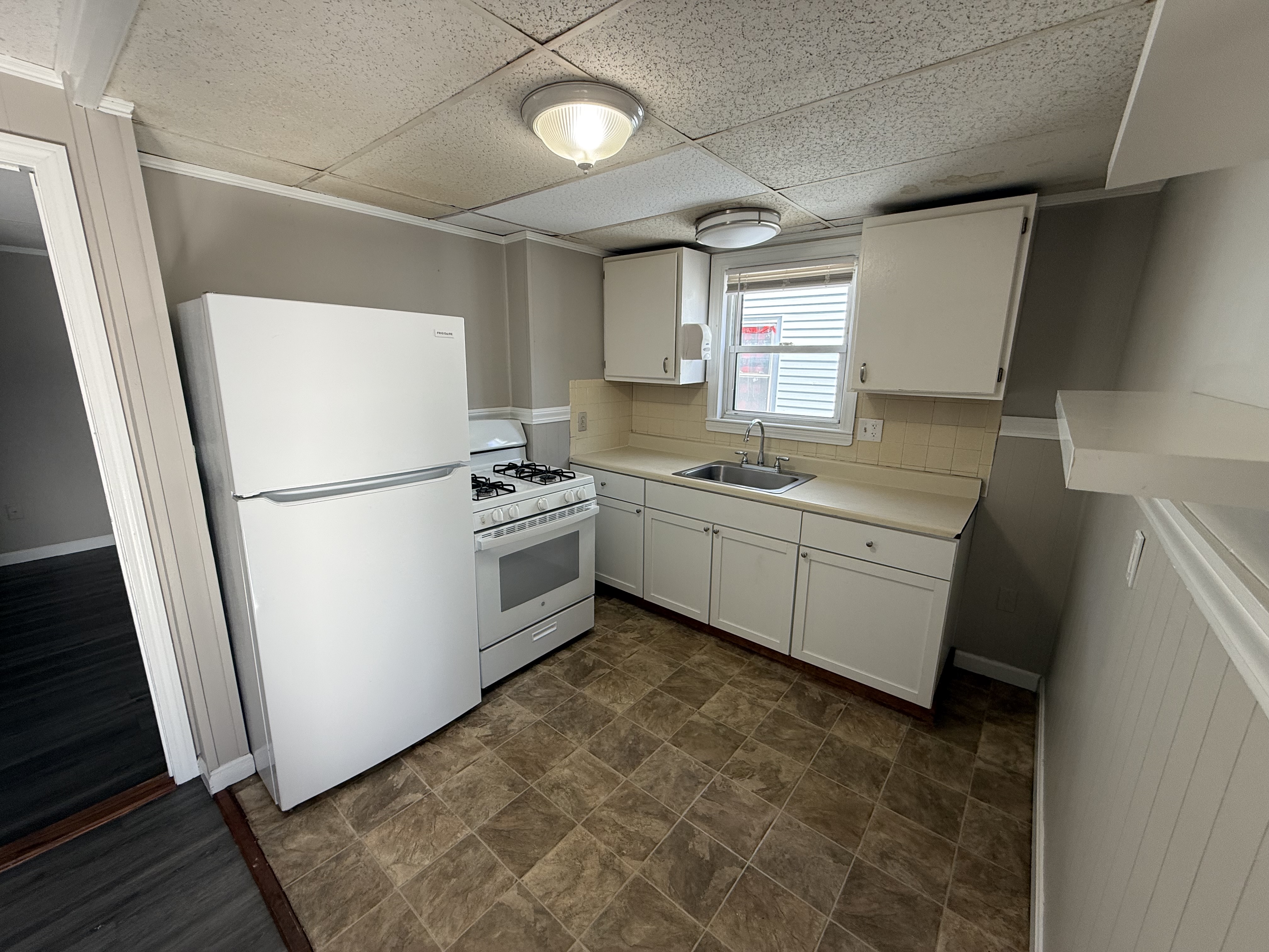 Functional kitchen with gas stove, refrigerator, and counter space