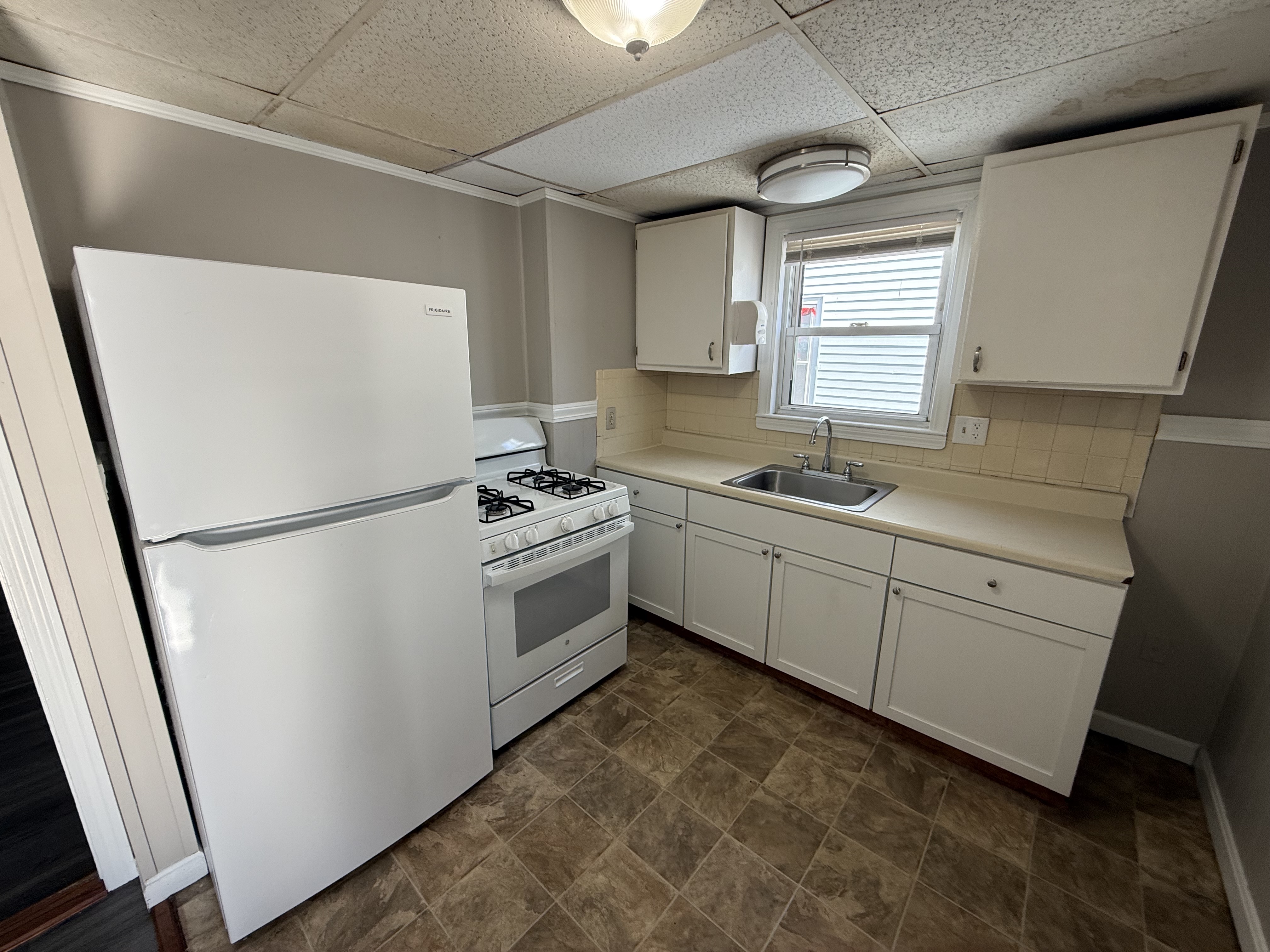 Kitchen with white cabinets and tile floor