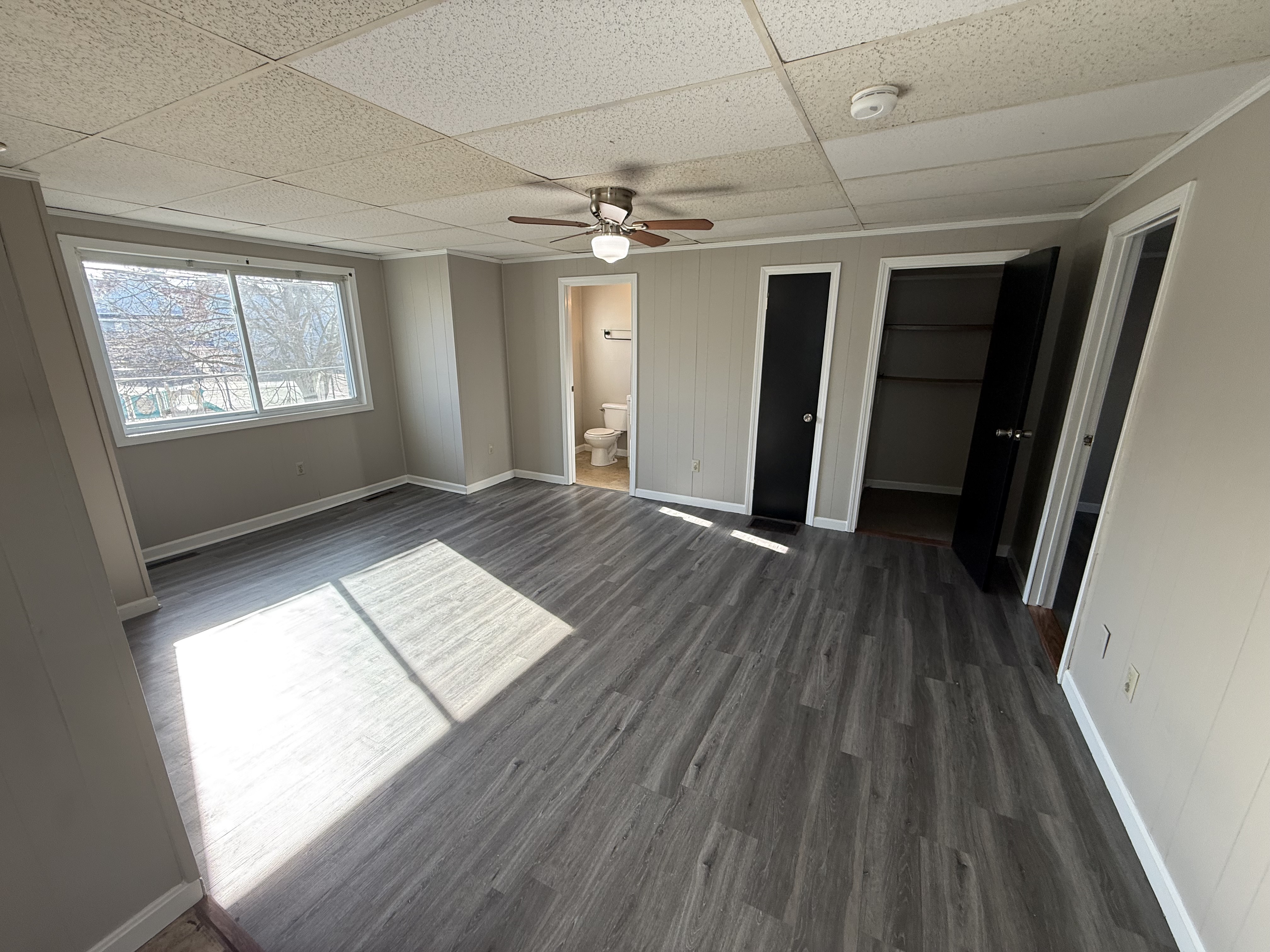Living room with ceiling fan and bright windows