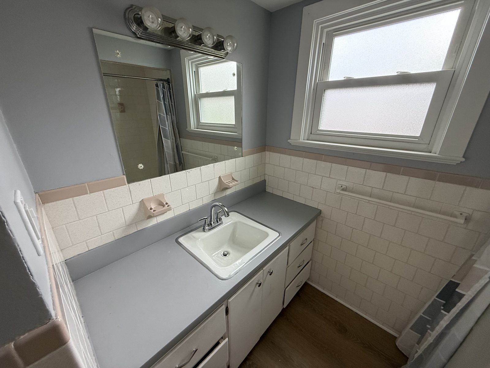 Bathroom vanity with sink, mirror, light bar, and frosted privacy window in apartment 1N at 795 North Underwood Street Fall River MA