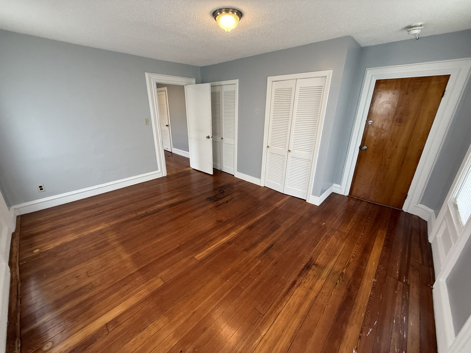 Hallway with multiple closets and a wood interior door in apartment 1N at 795 North Underwood Street Fall River MA