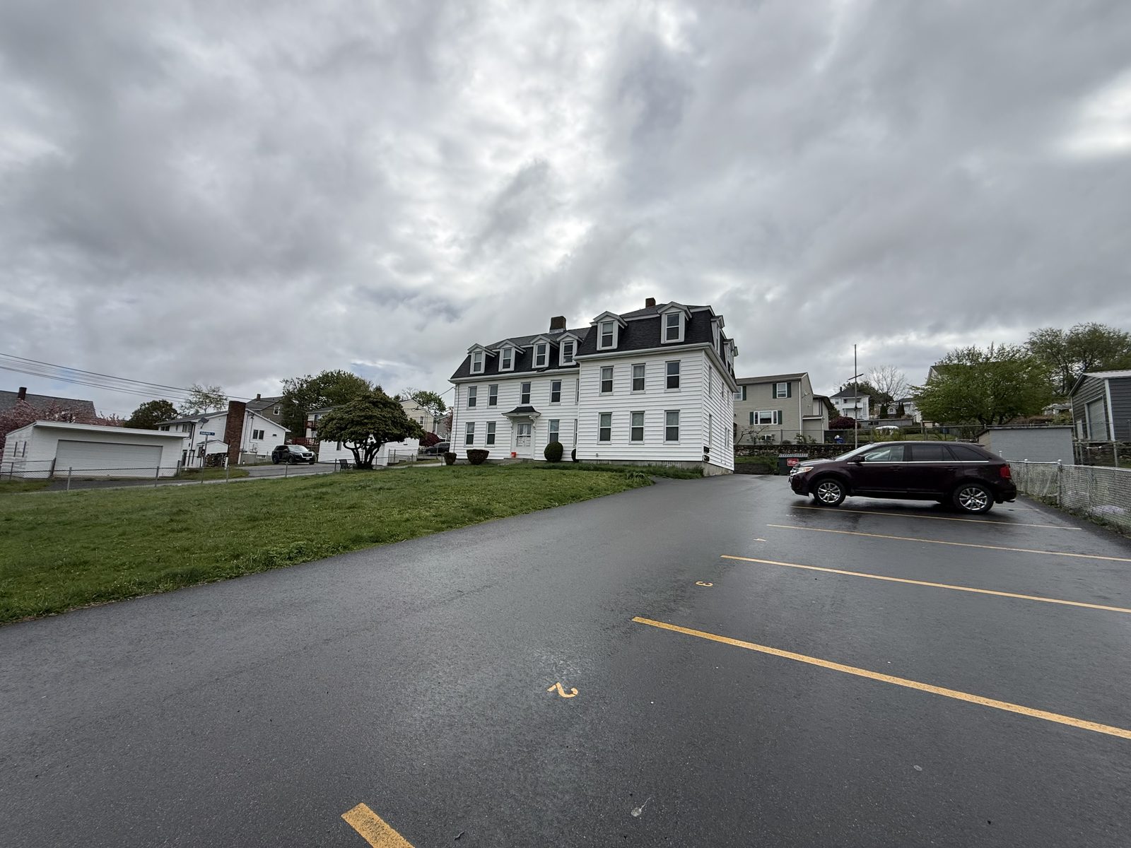 Off-street parking lot at 795 North Underwood Street Fall River MA with paved spaces and view of neighboring multifamily home