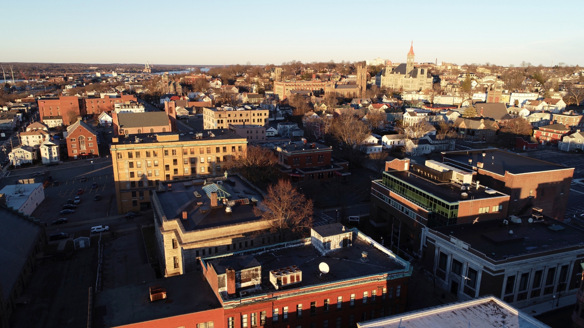 Aerial view of historic downtown Fall River, Massachusetts at golden hour, showing City Hall, Central Congregational Church, and the dome of Bristol County Superior Courthouse.